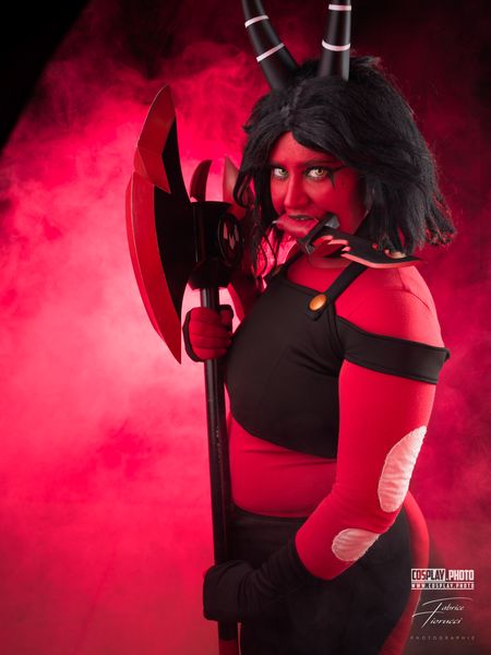 Cosplay démone rouge à cornes, hache massive sur fumée rose — Fabrice Fiorucci Photographe
