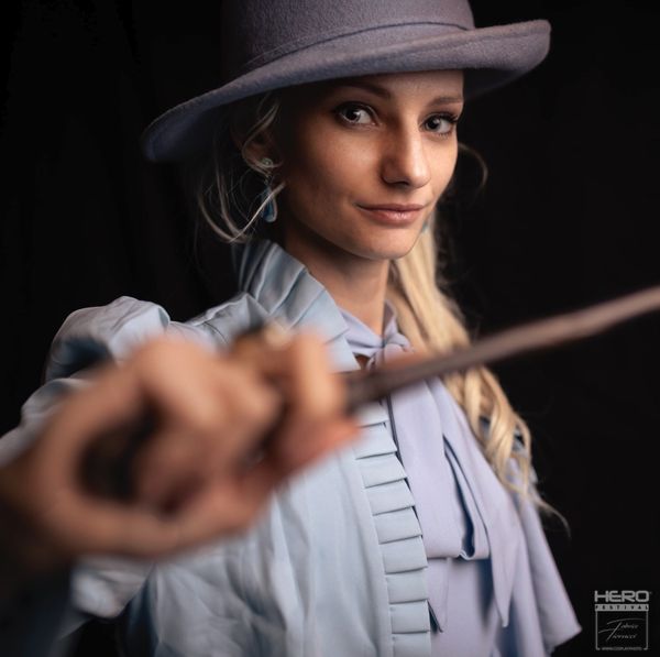 Cosplay Tina Goldstein (Animaux Fantastiques / Harry Potter), chapeau gris et baguette tendue — Fabrice Fiorucci Photographe